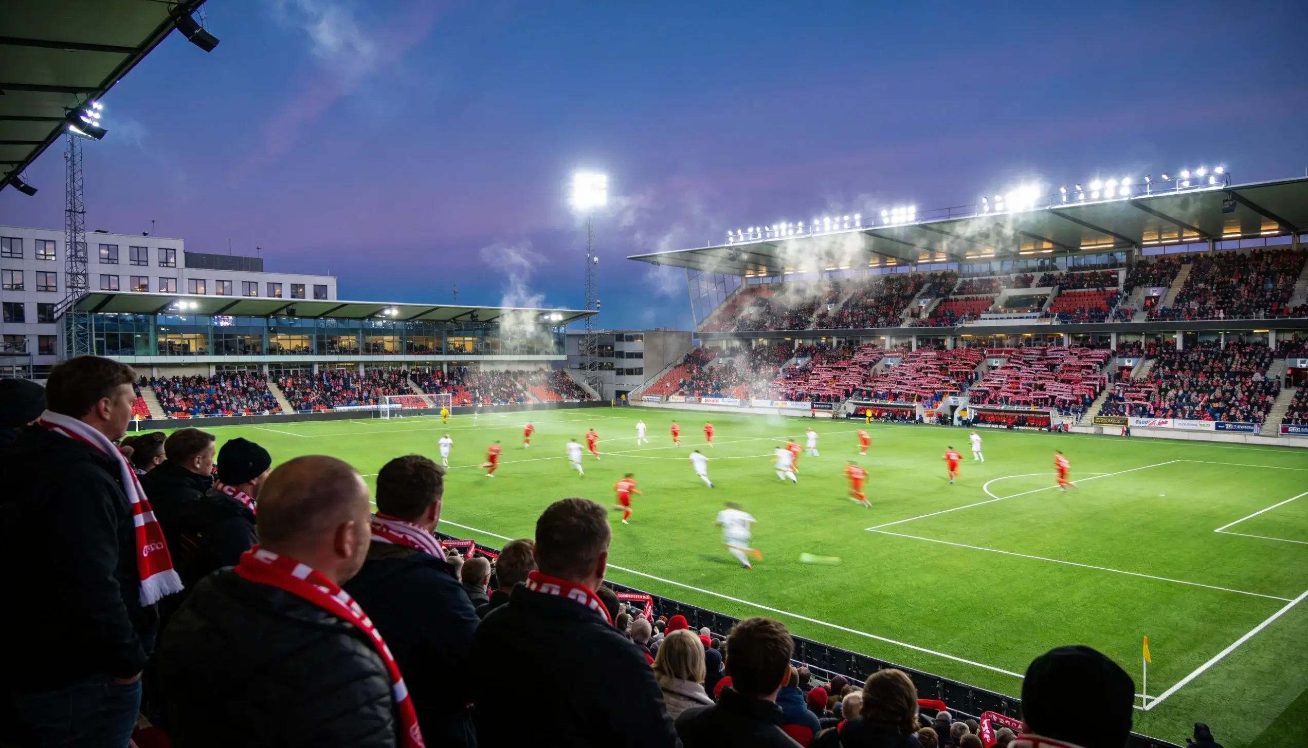 Fodboldstadion med tilskuere under en Superligaen-kamp i Danmark